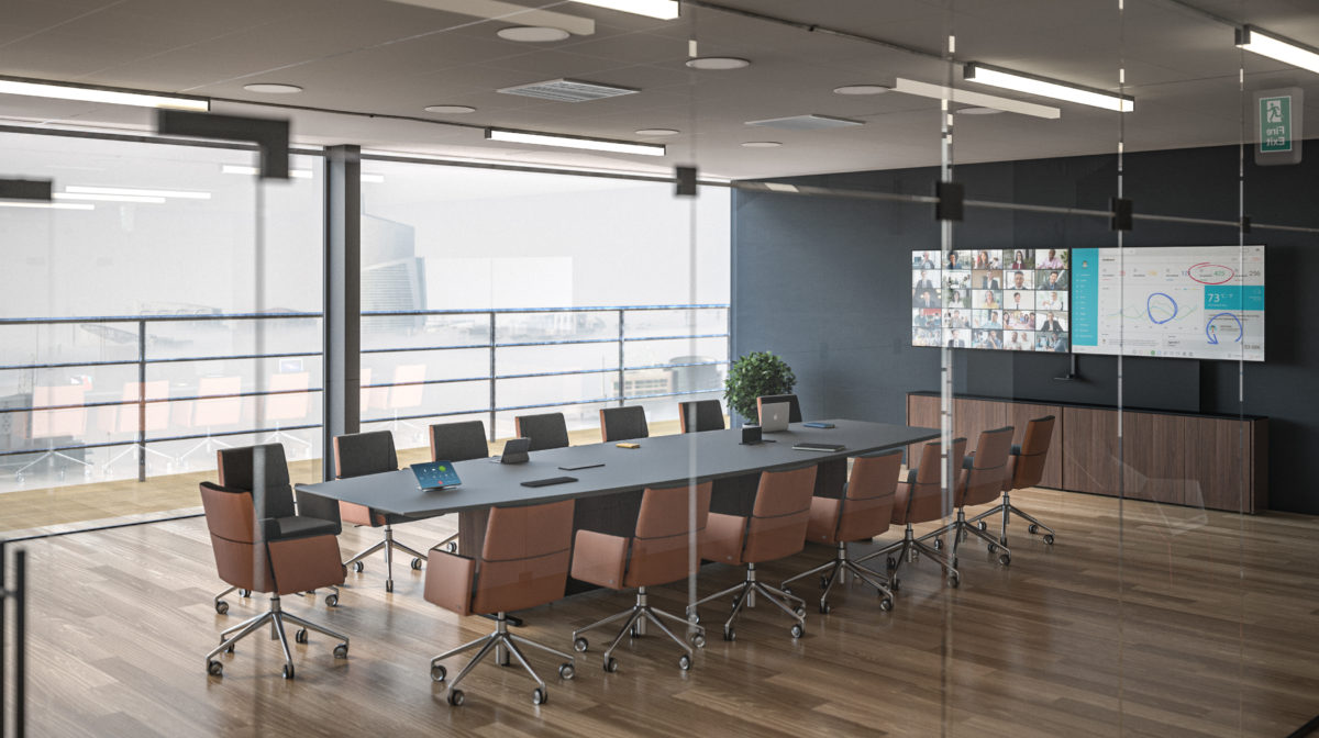 Upscale conference room with highly polished round table and executive chairs overlooking a sunrise through a wall of windows.