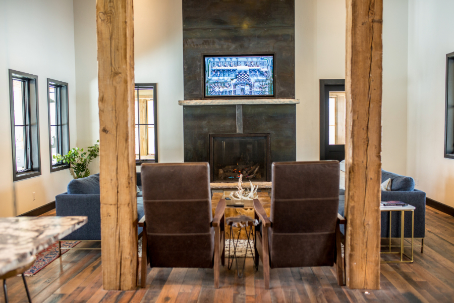 A living room with a fireplace, two chairs, and a TV.