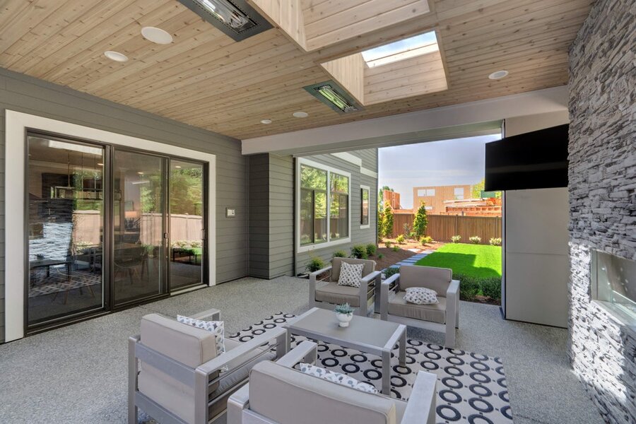 An outdoor patio and yard showcasing installed smart audio and visual systems.